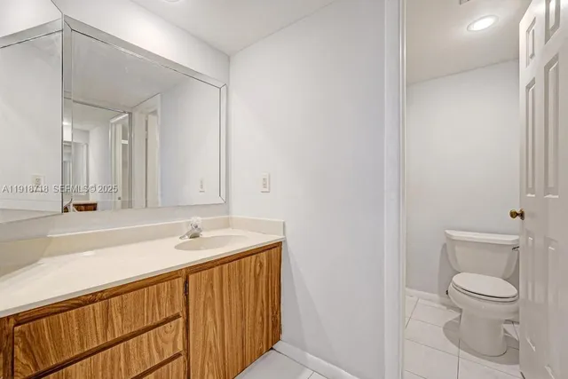 a bathroom with a sink a toilet and a large mirror