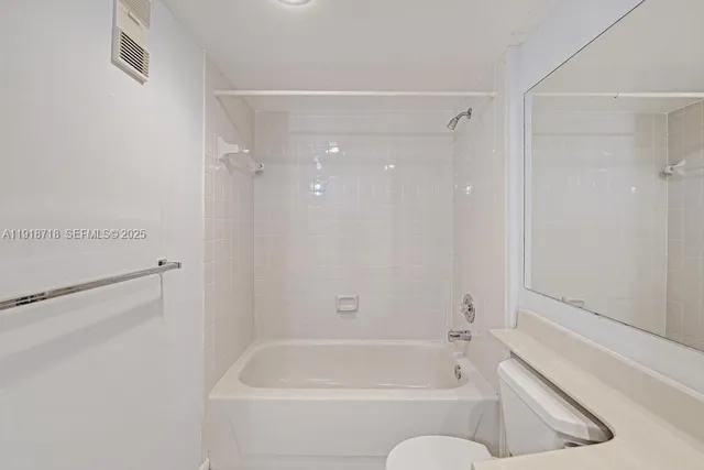 a bathroom with a tub shower and toilet