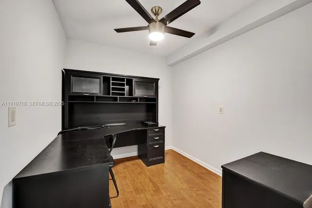 a kitchen with a refrigerator and ceiling fan