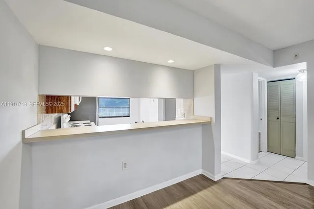 a kitchen with stainless steel appliances a sink dishwasher a refrigerator and a stove with wooden floor