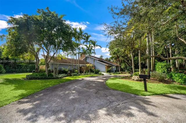 a front view of a house with a yard and trees