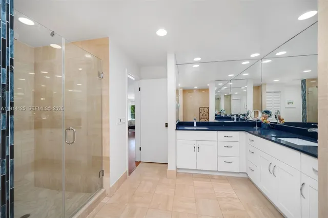 a bathroom with a granite countertop sink mirror and shower