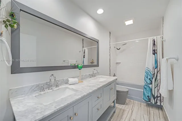 a bathroom with a granite countertop sink toilet and shower