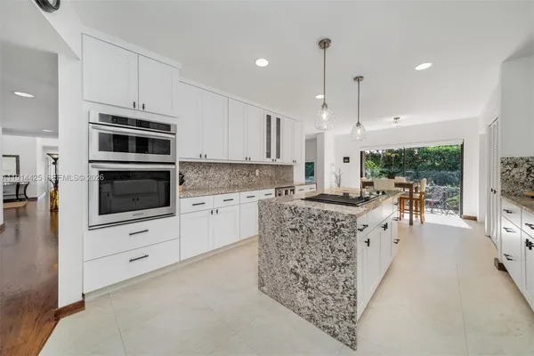 a kitchen with stainless steel appliances kitchen island granite countertop a stove and a sink