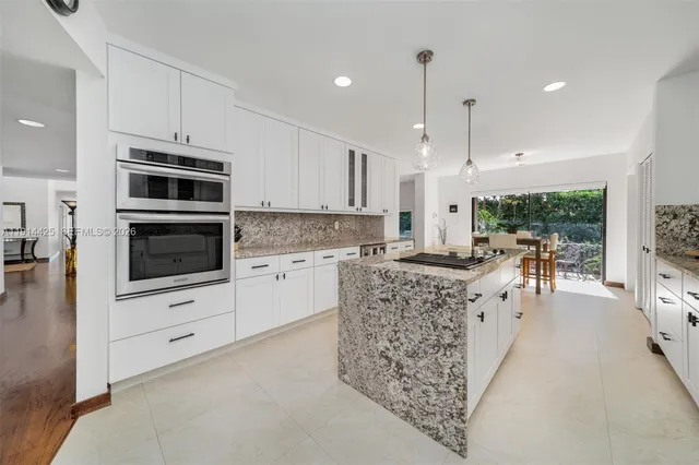 a kitchen with stainless steel appliances kitchen island granite countertop a stove and a sink