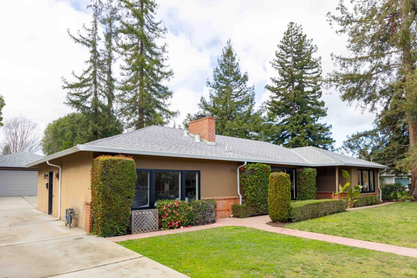 a front view of a house with a garden and yard