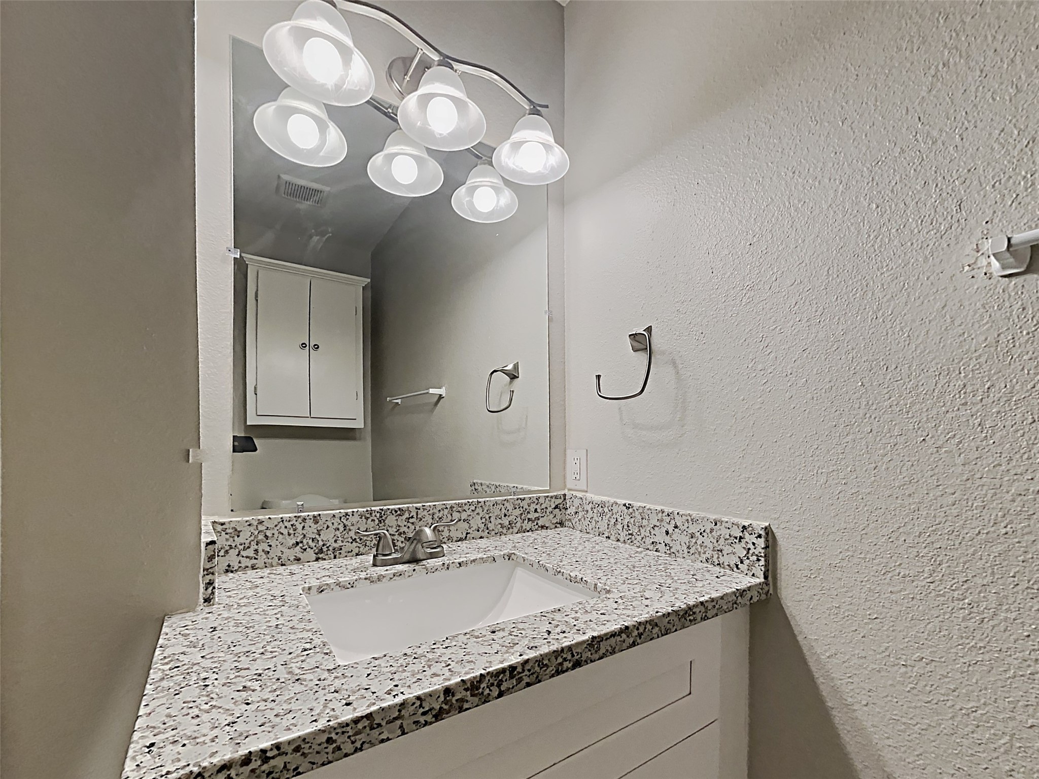 14020 Schroeder Road, Unit 108 Houston, TX 77070 - Photo 12 of 15 a bathroom with a granite countertop sink and a mirror