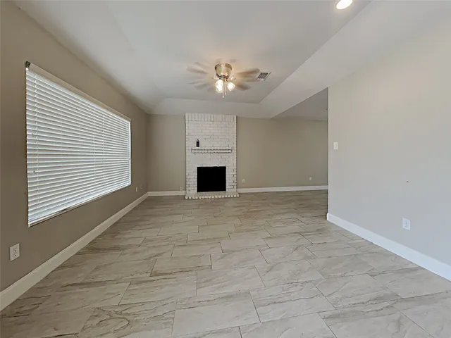 a view of an empty room with a ceiling fan and a window