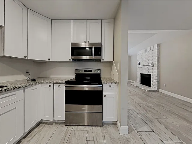 a kitchen with stainless steel appliances a stove a sink and a microwave