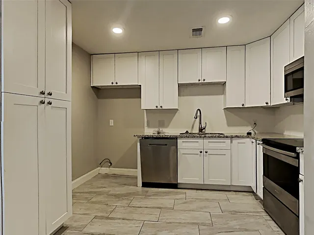 a kitchen with a stove sink and cabinets