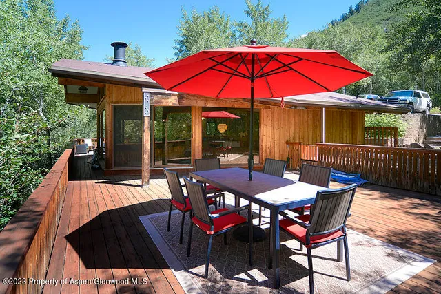 a view of a patio with table and chairs under an umbrella