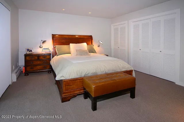 a bed sitting in a room with furniture and a closet