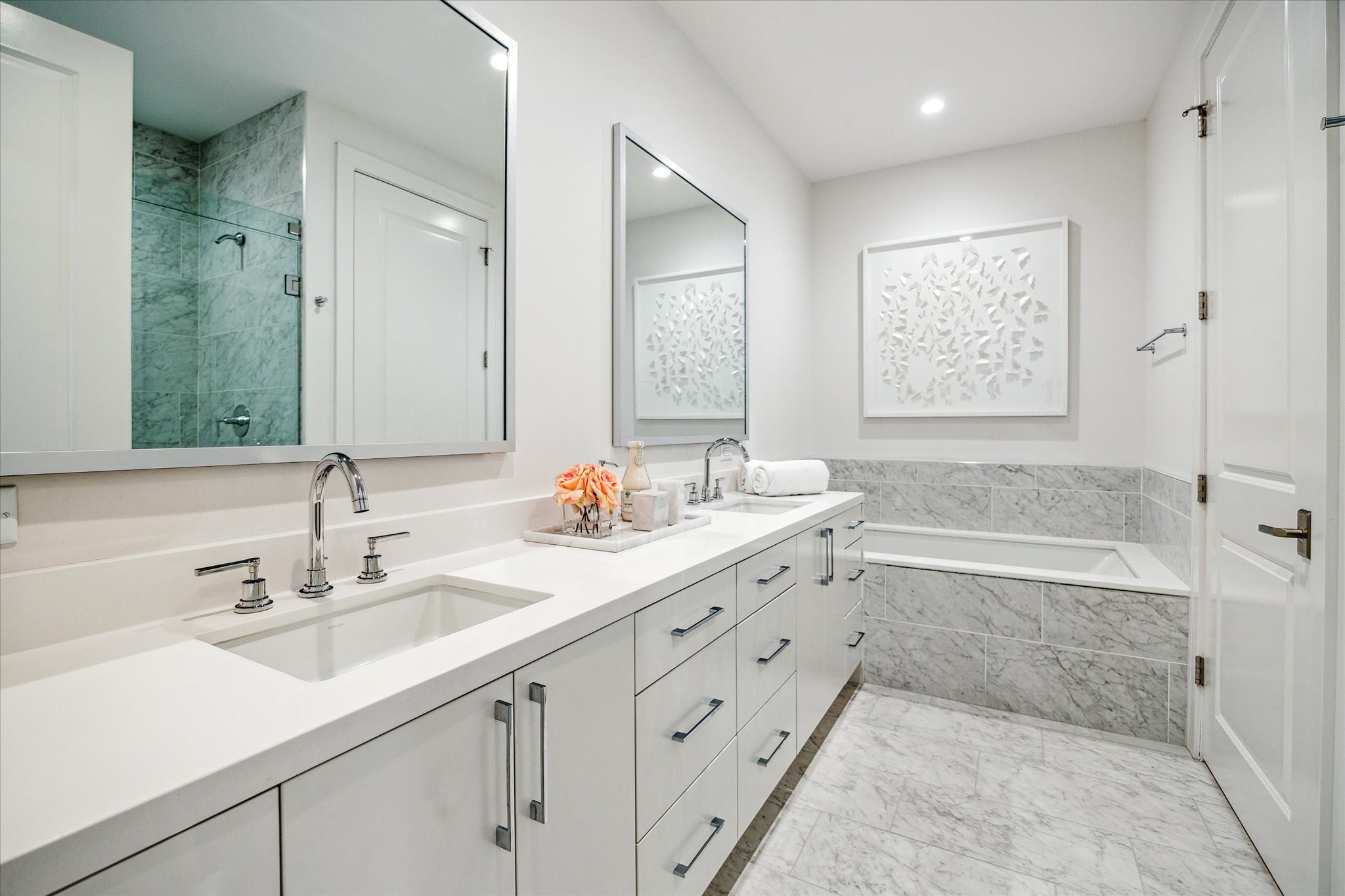 5656 San Felipe Street, Unit 606 Houston, TX 77056 - Photo 27 of 34 a bathroom with double vanity sinks a large mirror and a bathtub