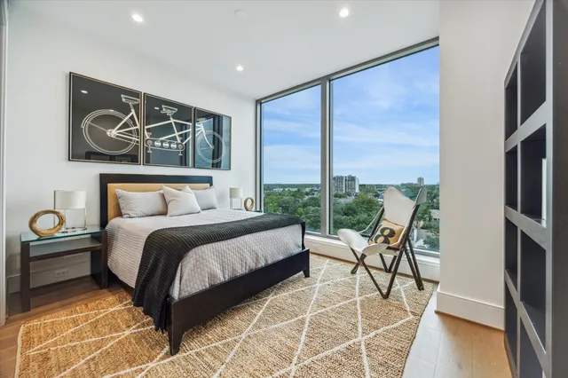 a view of a swimming pool with outdoor seating and a floor to ceiling window