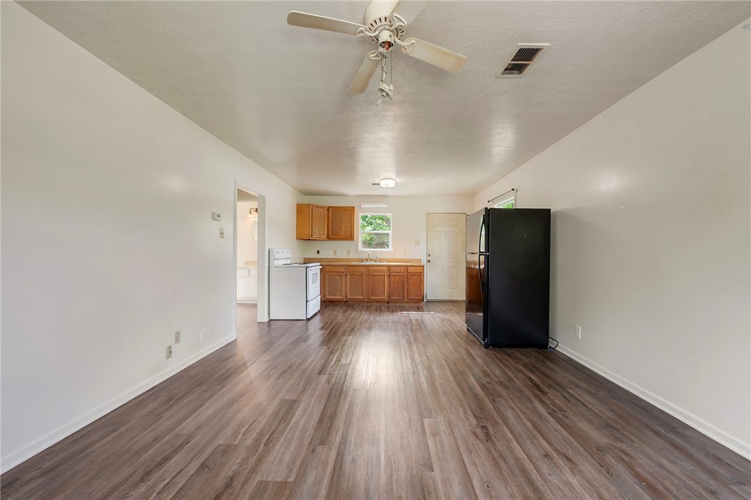 400 Robertson Street Bryan, TX 77803 - Photo 3 of 9 an empty room with wooden floor cabinet and windows