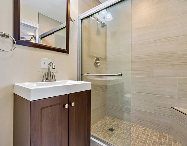 a bathroom with a shower sink and mirror