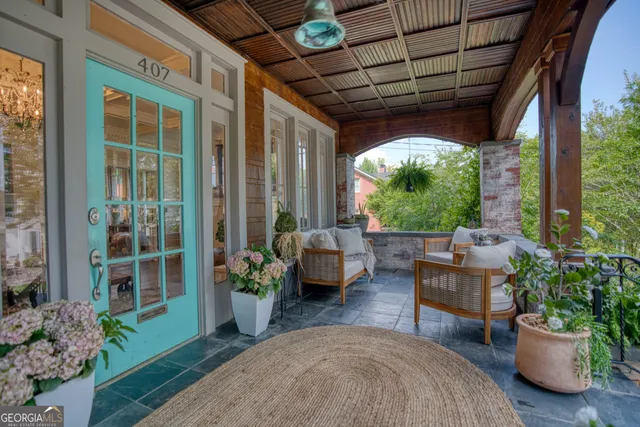 a living room with furniture a flat screen tv and a chandelier
