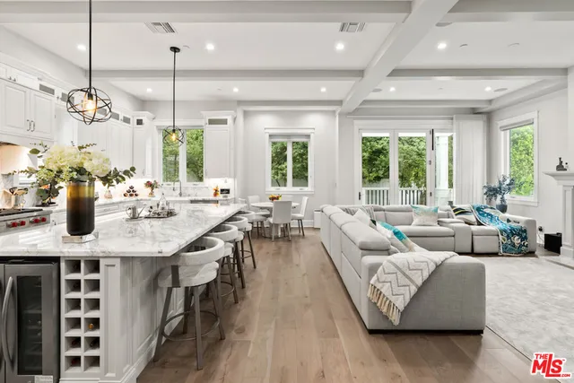 a kitchen with center island white cabinets and refrigerator