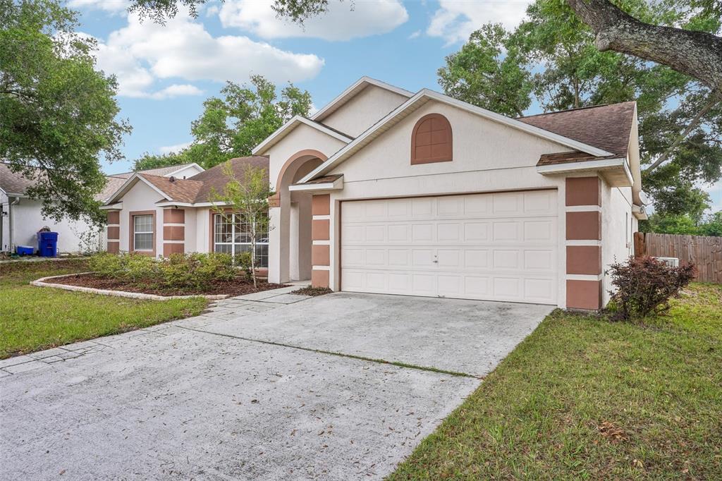 2596 Alclobe Circle Ocoee, FL 34761 - Photo 8 of 70 a front view of a house with a yard and garage