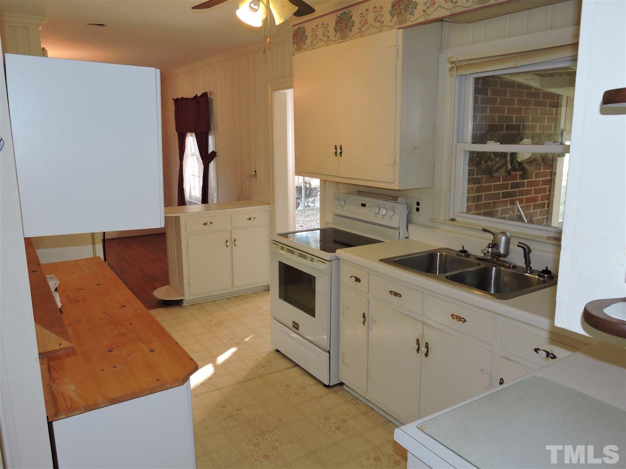 2580 Burlington Road Roxboro, NC 27574 - Photo 5 of 18 a kitchen with stainless steel appliances granite countertop a sink a stove and a refrigerator