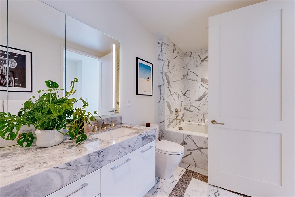240 Devonshire Street, Unit 5206 Boston, MA 02110 - Photo 10 of 40 a bathroom with a granite countertop sink mirror vanity and toilet