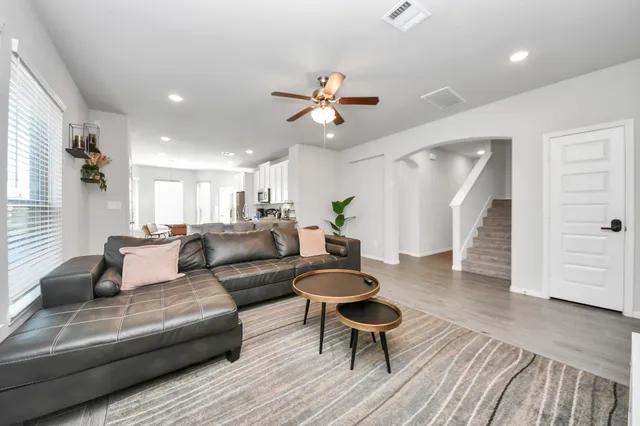 a living room with furniture and a wooden floor