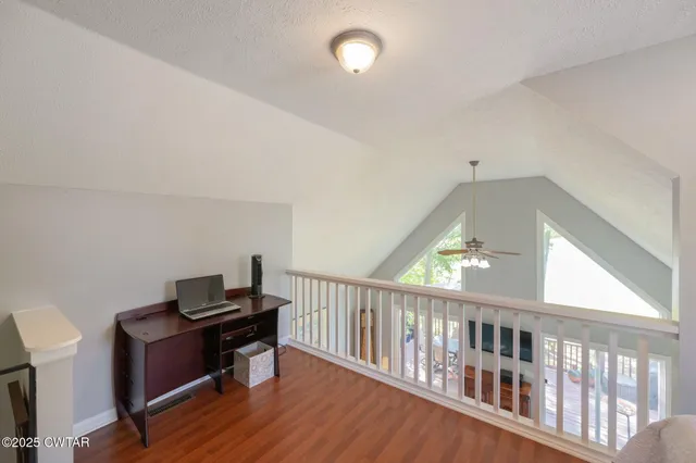 a view of a workspace with furniture and a window