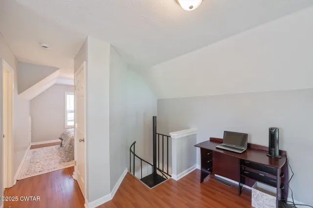 a view of a workspace with furniture and wooden floor