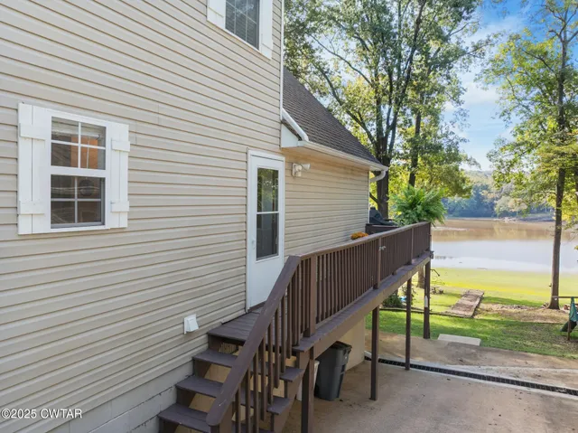 a view of a house with backyard and a tree