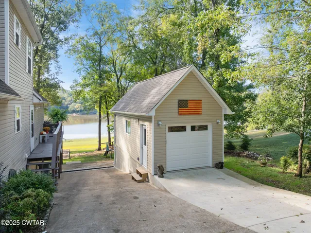 a view of a house with a yard and large tree