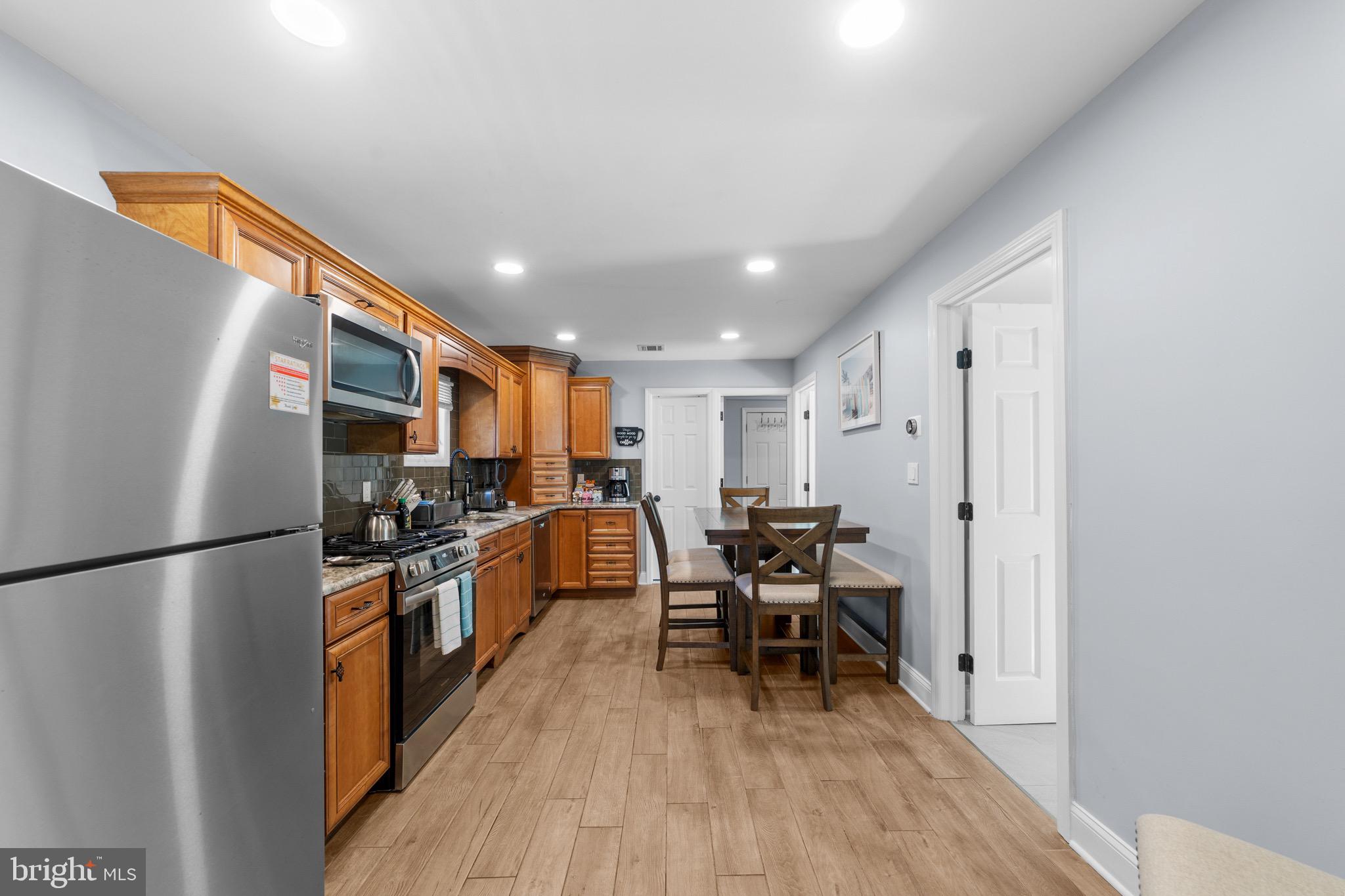 140 North Ocean Avenue Point Pleasant Beach, NJ 08742 - Photo 21 of 49 a kitchen with stainless steel appliances a refrigerator a stove a sink dishwasher and a dining table with wooden floor