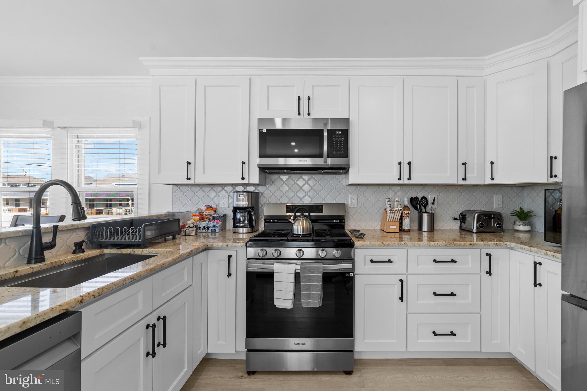 140 North Ocean Avenue Point Pleasant Beach, NJ 08742 - Photo 6 of 49 a kitchen with white cabinets and stainless steel appliances