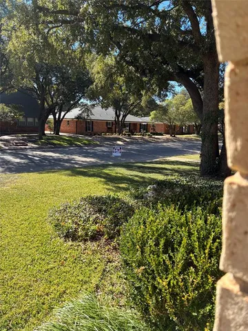 a white house that has tree in front of it