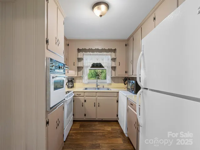 a kitchen with granite countertop a stove sink and cabinets