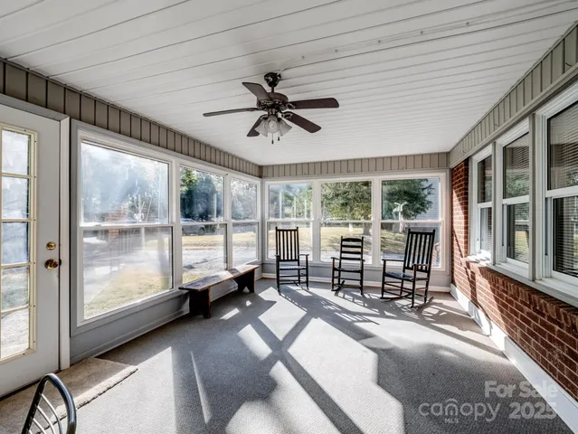 a living room with furniture two window and a flat screen tv
