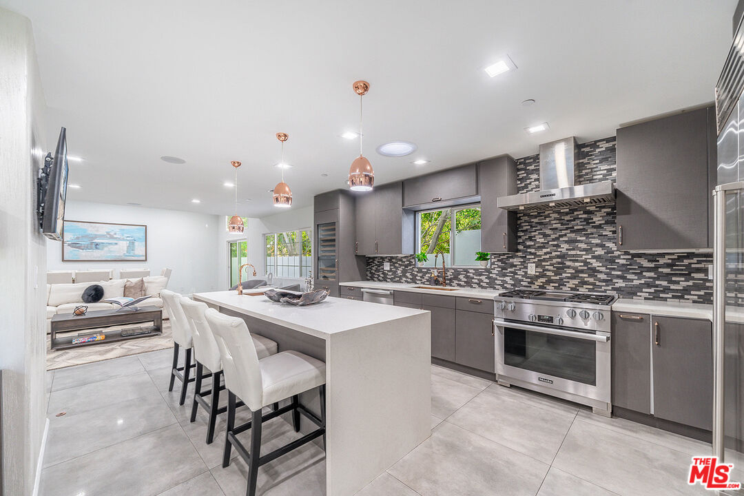 5010 Fulton Avenue Sherman Oaks, CA 91423 - Photo 16 of 55 a kitchen with stainless steel appliances a stove a sink a oven a dining table and chairs