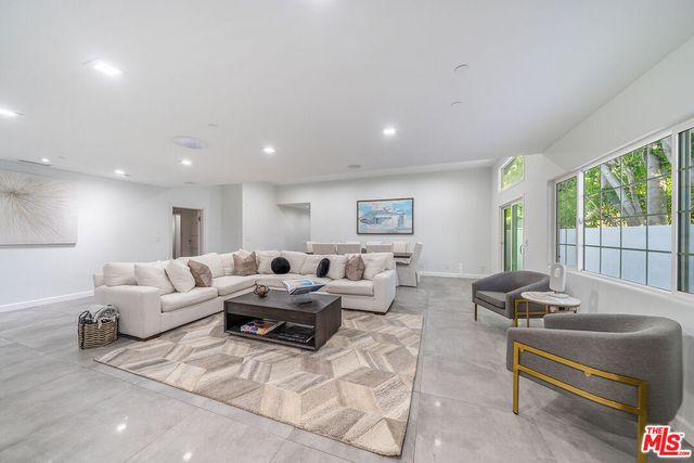 a living room with furniture and a painting on the wall