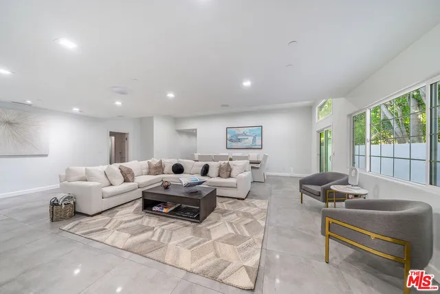 a living room with furniture and a painting on the wall