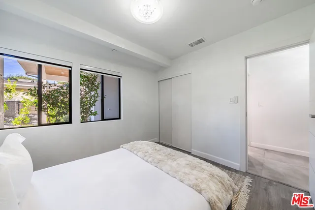 a bedroom with a bed and wooden floor