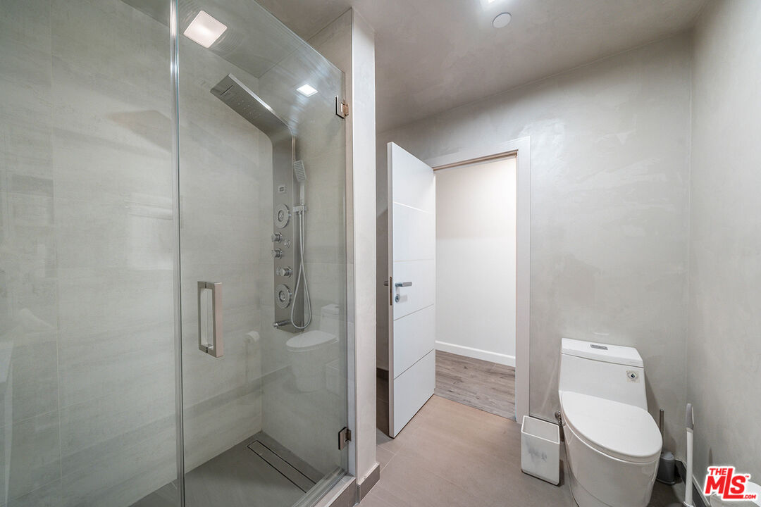 5010 Fulton Avenue Sherman Oaks, CA 91423 - Photo 31 of 55 a bathroom with a granite countertop toilet a sink and shower