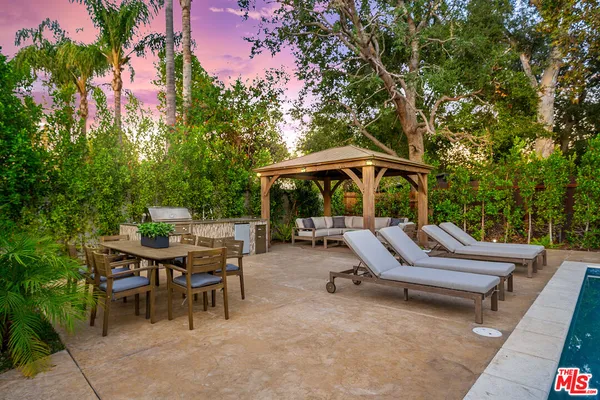 a view of backyard with swimming pool and furniture