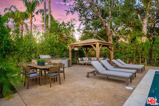 a view of backyard with swimming pool and furniture