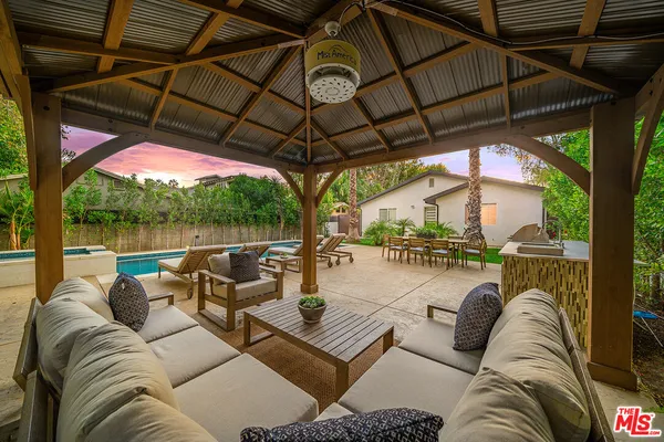 a view of a patio with a table chairs and a swimming pool