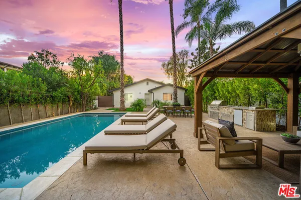 a view of a house with pool and sitting area