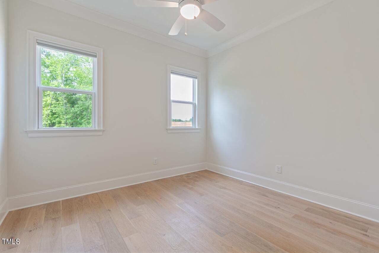 816 Crimson Rdg Trail Fuquay-Varina, NC 27526 - Photo 21 of 42 an empty room with wooden floor and windows