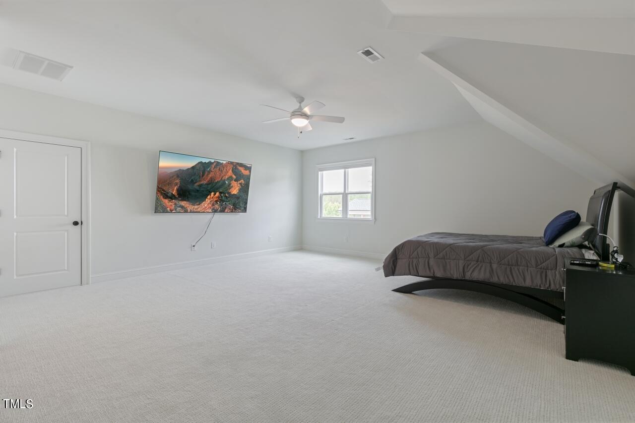816 Crimson Rdg Trail Fuquay-Varina, NC 27526 - Photo 28 of 42 a bedroom with a bed a window and a flat screen tv
