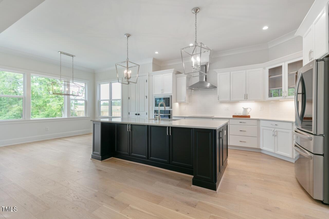 816 Crimson Rdg Trail Fuquay-Varina, NC 27526 - Photo 6 of 42 a kitchen with stainless steel appliances granite countertop a refrigerator a sink dishwasher a stove and white cabinets with wooden floor