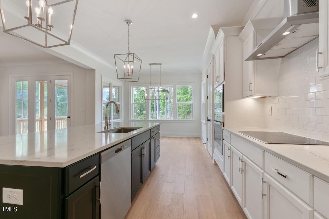 816 Crimson Rdg Trail Fuquay-Varina, NC 27526 - Photo 8 of 42 a kitchen with stainless steel appliances granite countertop a sink a stove and a wooden floors