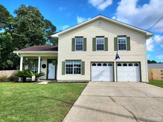 a front view of a house with a yard and trees