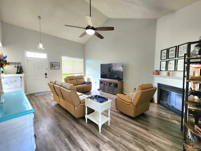 a living room with furniture a flat screen tv and a potted plant